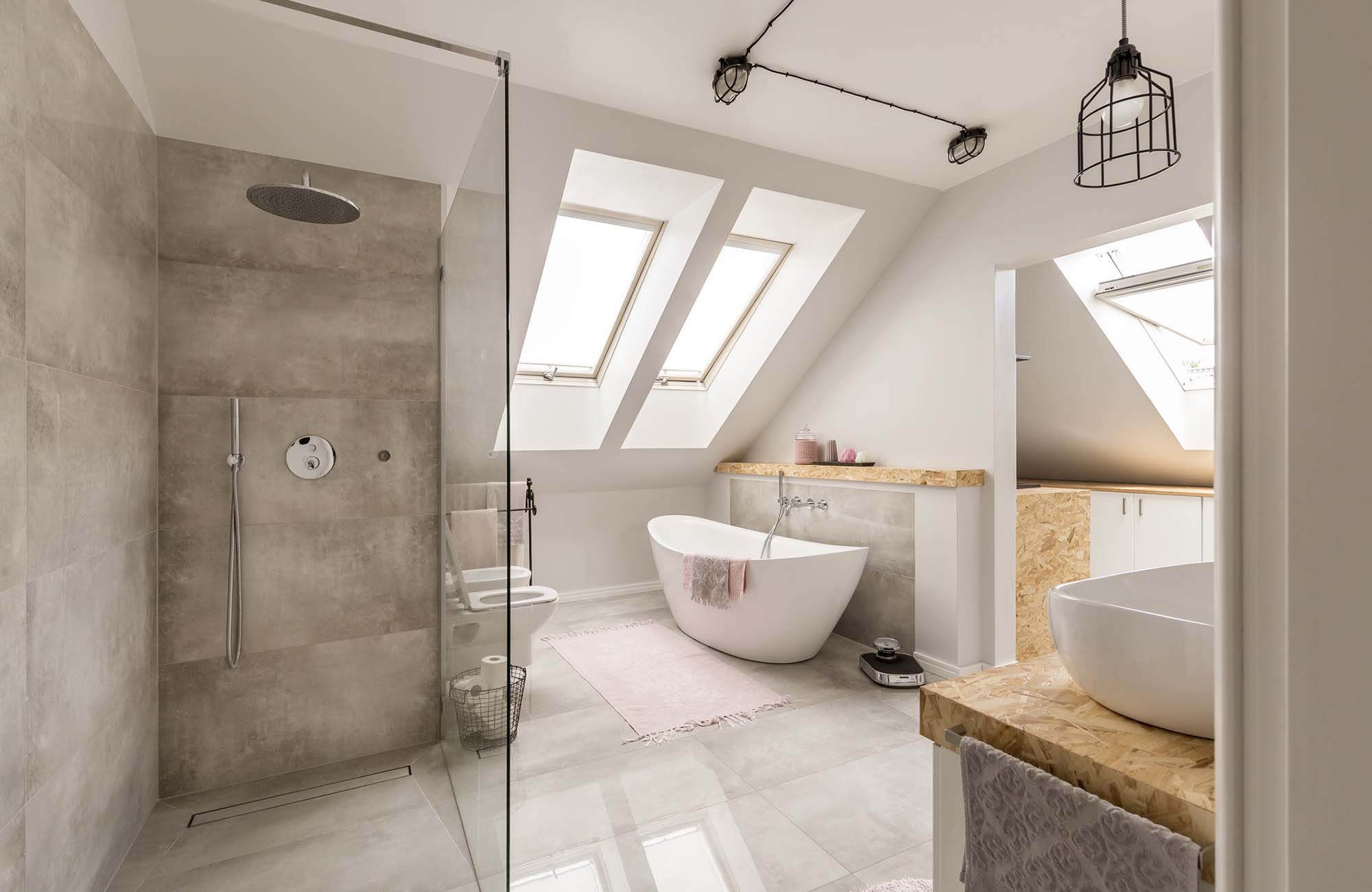 Modern bathroom interior with minimalistic shower and lighting, white toilet, sink, bathtub and roofwindows